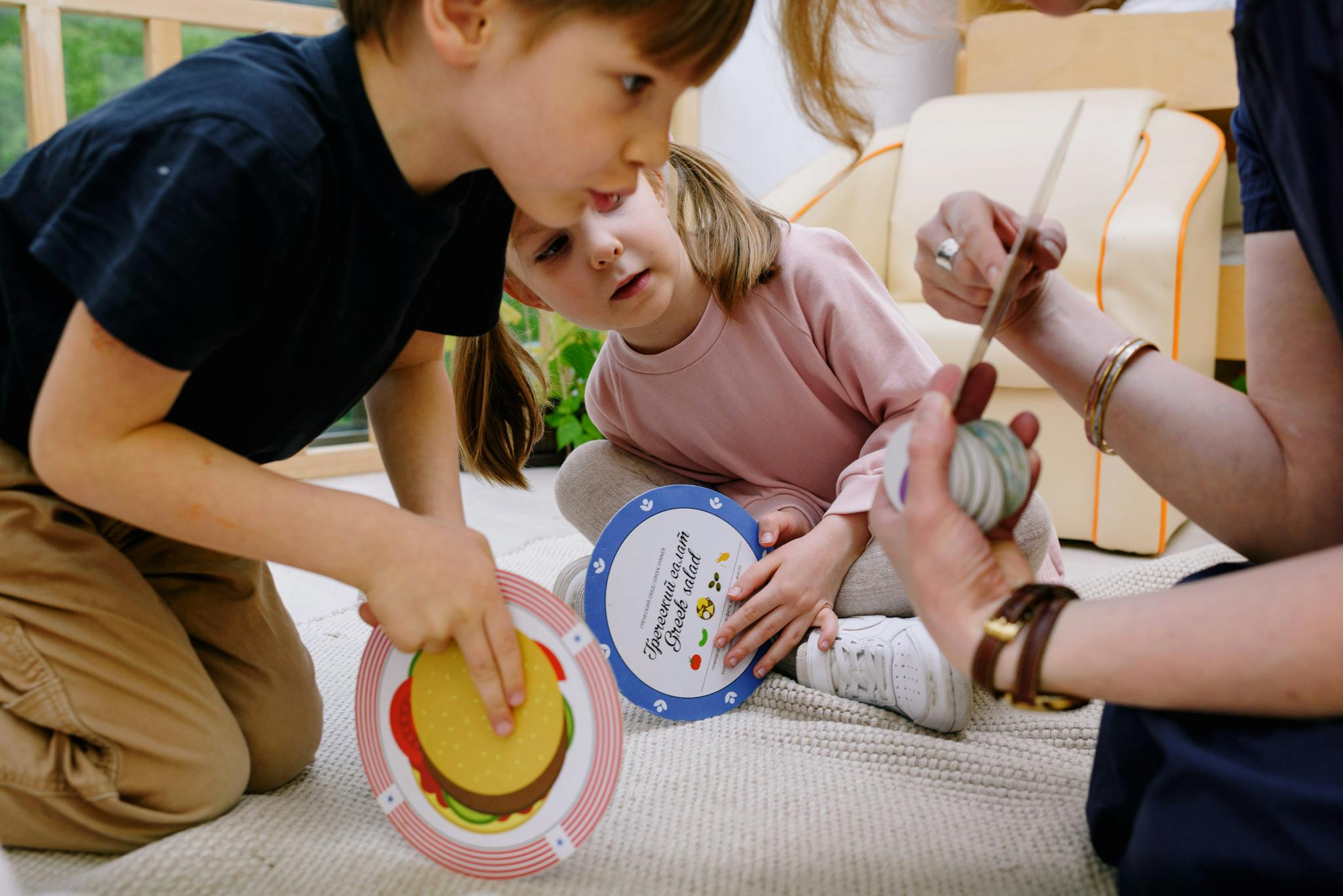 Children playing with educational toys in a playroom with a caregiver, fostering creativity and concentration.